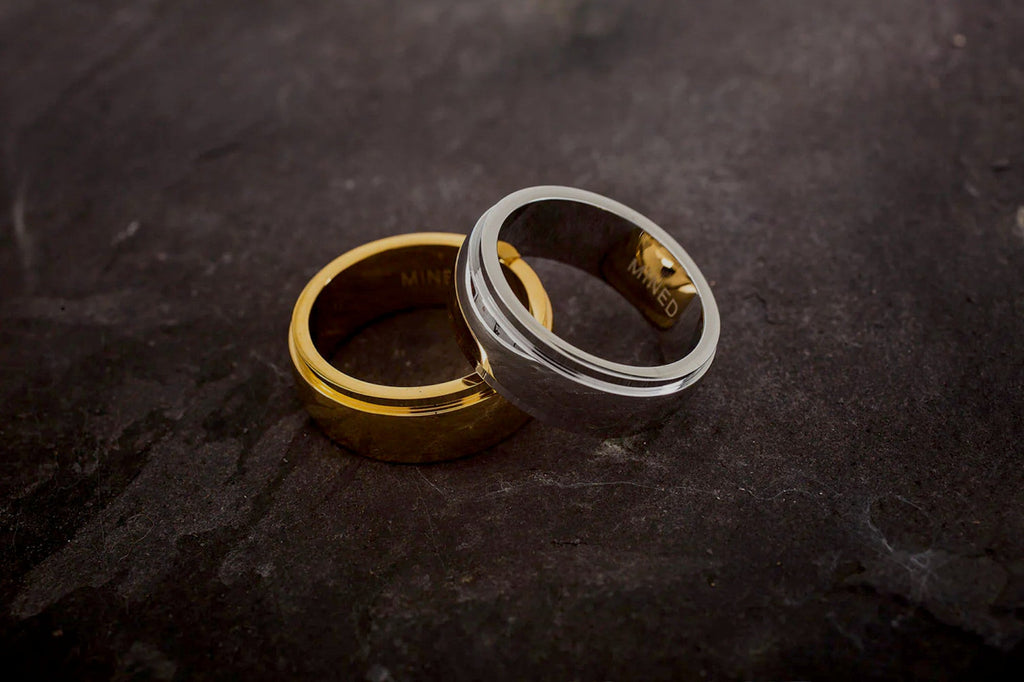 two rings, one gold on platinum, on a table.