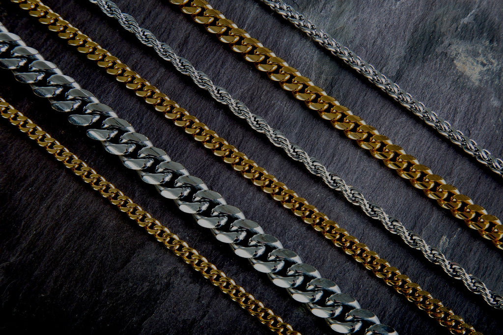 Several chains in gold and platinum, laid on a table.