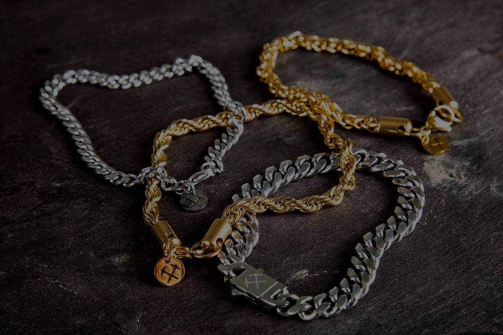 several mens chain bracelets on a table