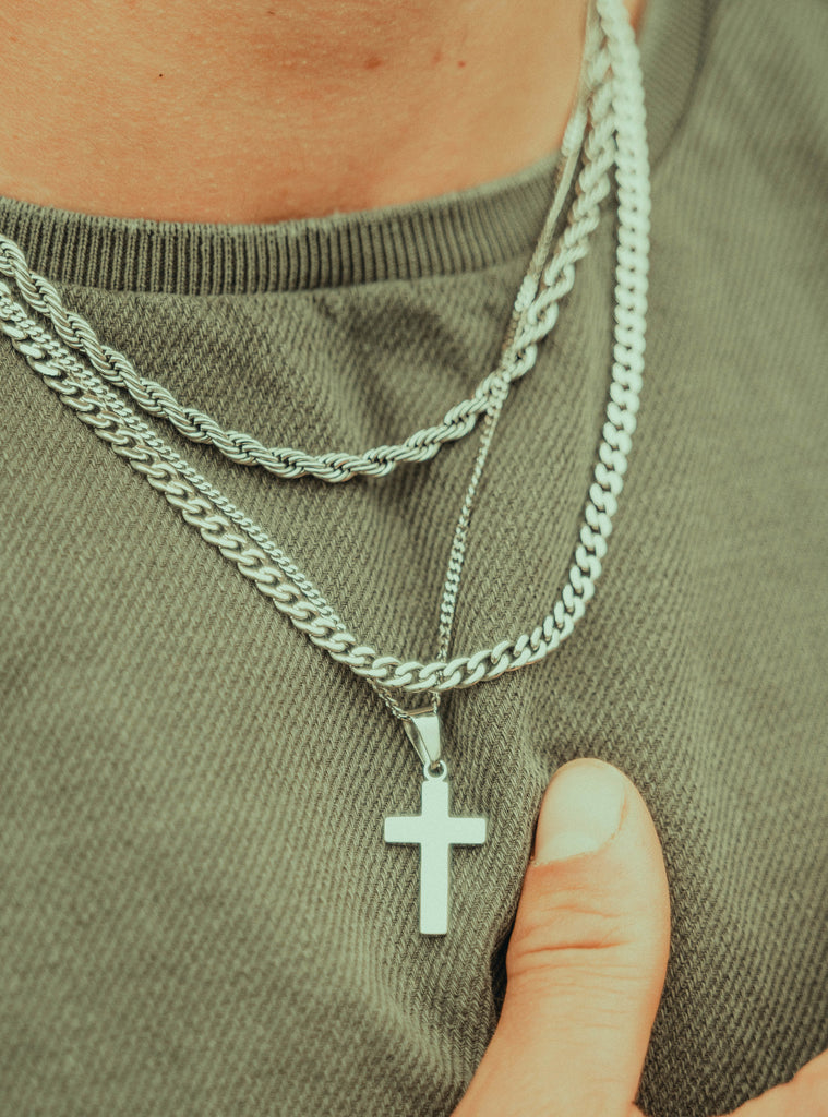 silver necklaces on a green tshirt. A platinum cross pendant.