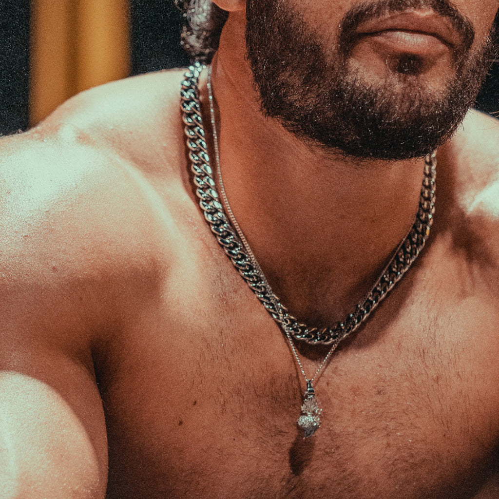 Man wearing a platinum cuban chain and a pendant necklace.